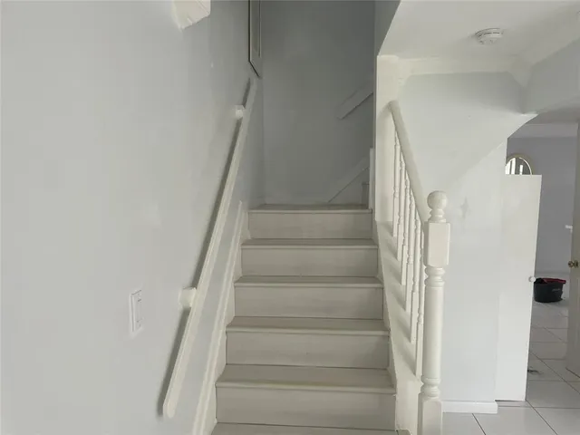 a view of staircase with white walls and white door