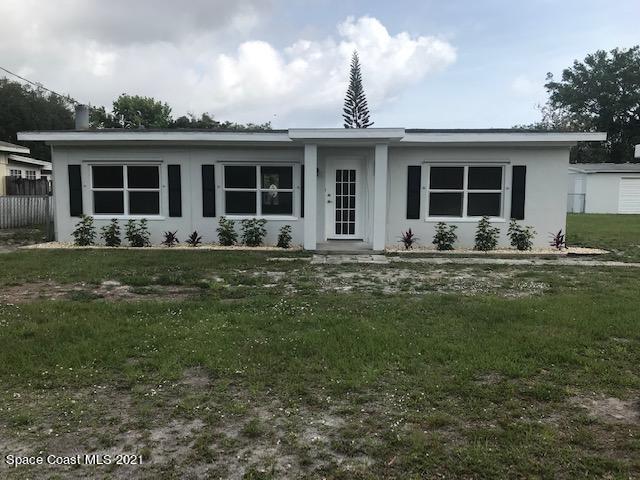2545 2nd Avenue Northeast Palm Bay, FL 32905 - Photo 1 of 32 a front view of a house with yard chairs and large tree
