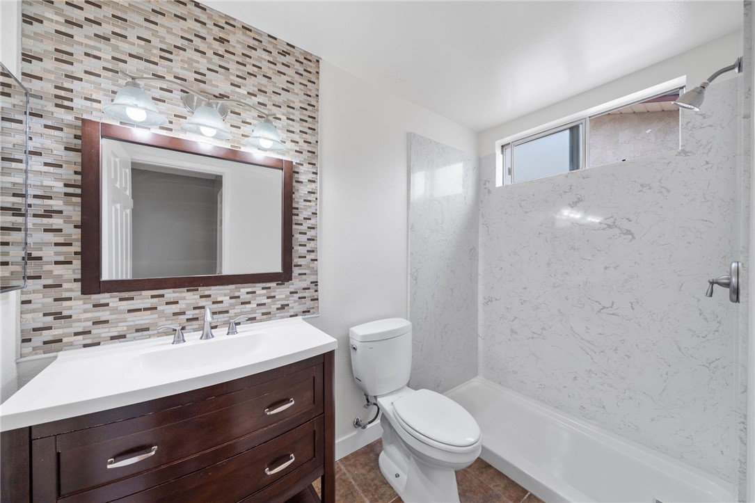 26932 Howard Street Menifee, CA 92586 - Photo 16 of 28 a bathroom with a sink toilet a mirror and shower
