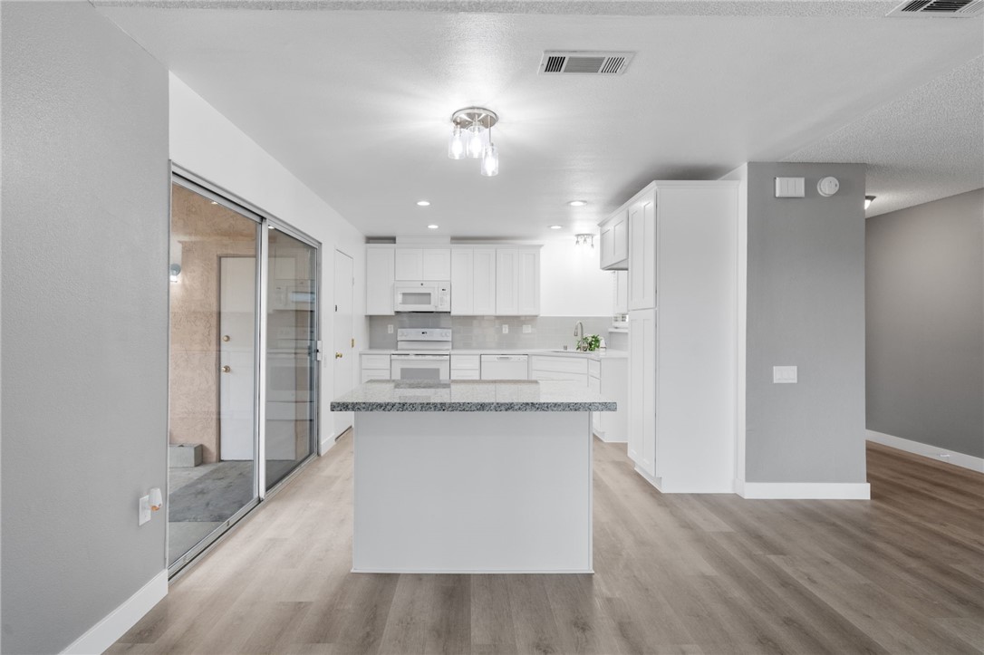26932 Howard Street Menifee, CA 92586 - Photo 2 of 28 a kitchen with stainless steel appliances a refrigerator and a stove top oven