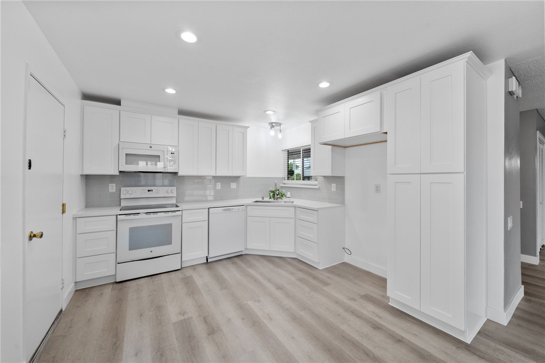 26932 Howard Street Menifee, CA 92586 - Photo 7 of 28 a kitchen with white cabinets and white appliances