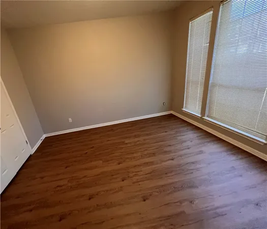an empty room with wooden floor and door