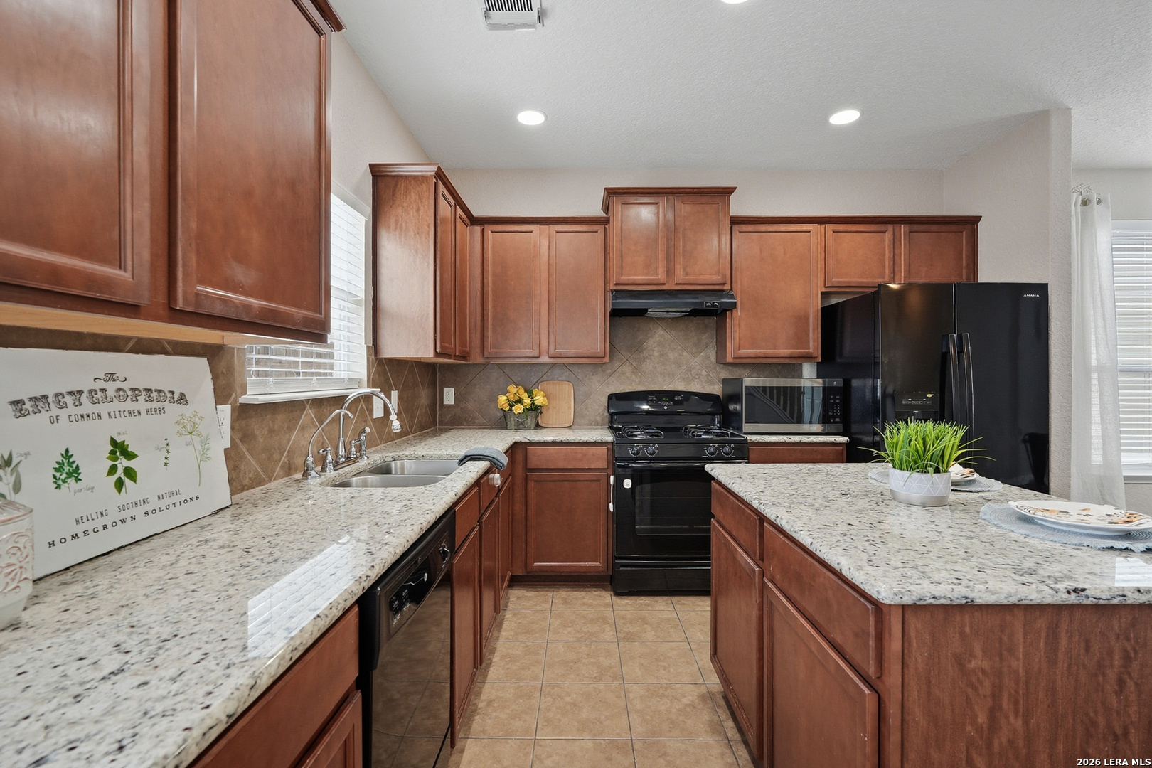 9519 Gold Stage Road San Antonio, TX 78254 - Photo 7 of 25 a kitchen with stainless steel appliances granite countertop a sink stove refrigerator and cabinets