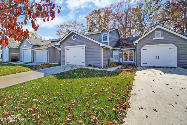 a view of a house with a big yard and large tree