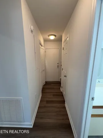 a view of a hallway with wooden floor and staircase