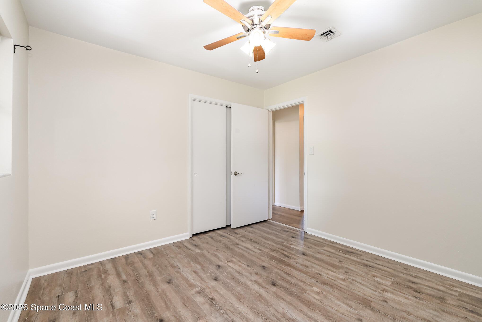 115 Gary Lane Cocoa, FL 32922 - Photo 12 of 29 an empty room with wooden floor and windows