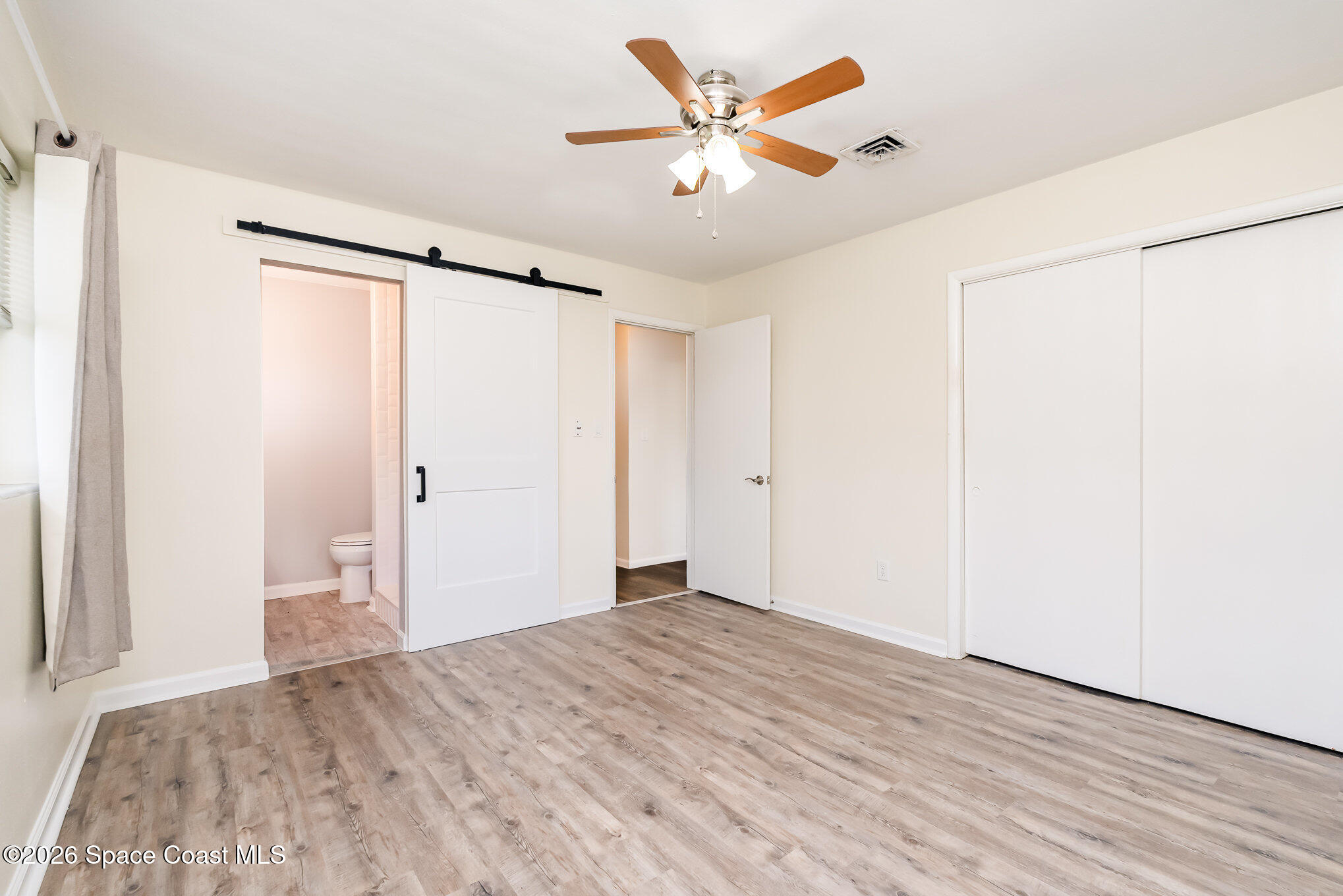 115 Gary Lane Cocoa, FL 32922 - Photo 16 of 29 a view of a big room with wooden floor and a ceiling fan