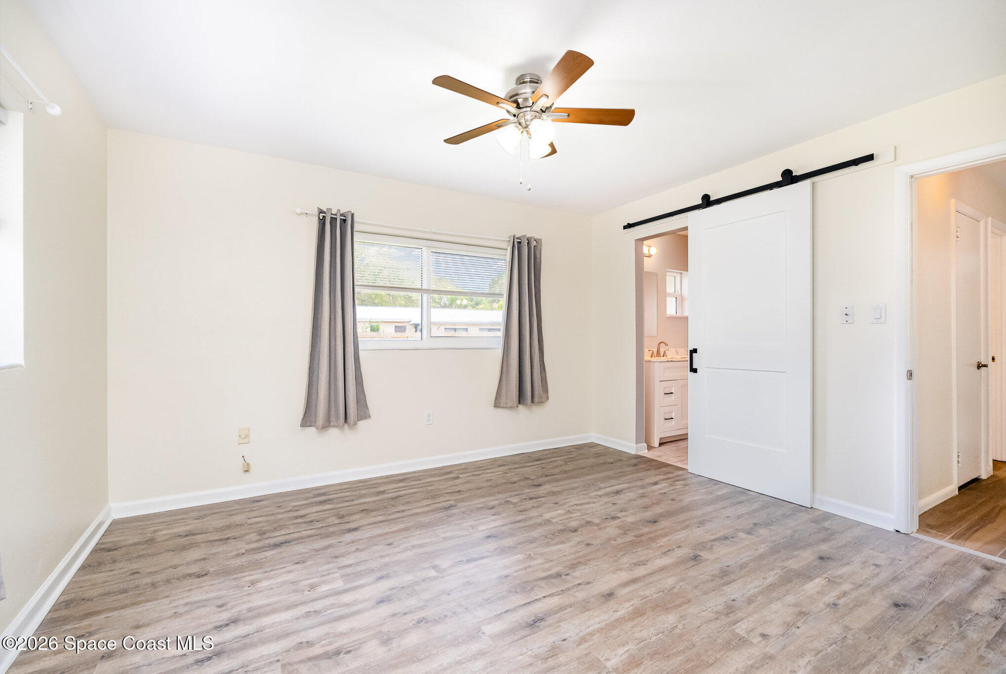 115 Gary Lane Cocoa, FL 32922 - Photo 17 of 29 a view of a livingroom with wooden floor and a ceiling fan