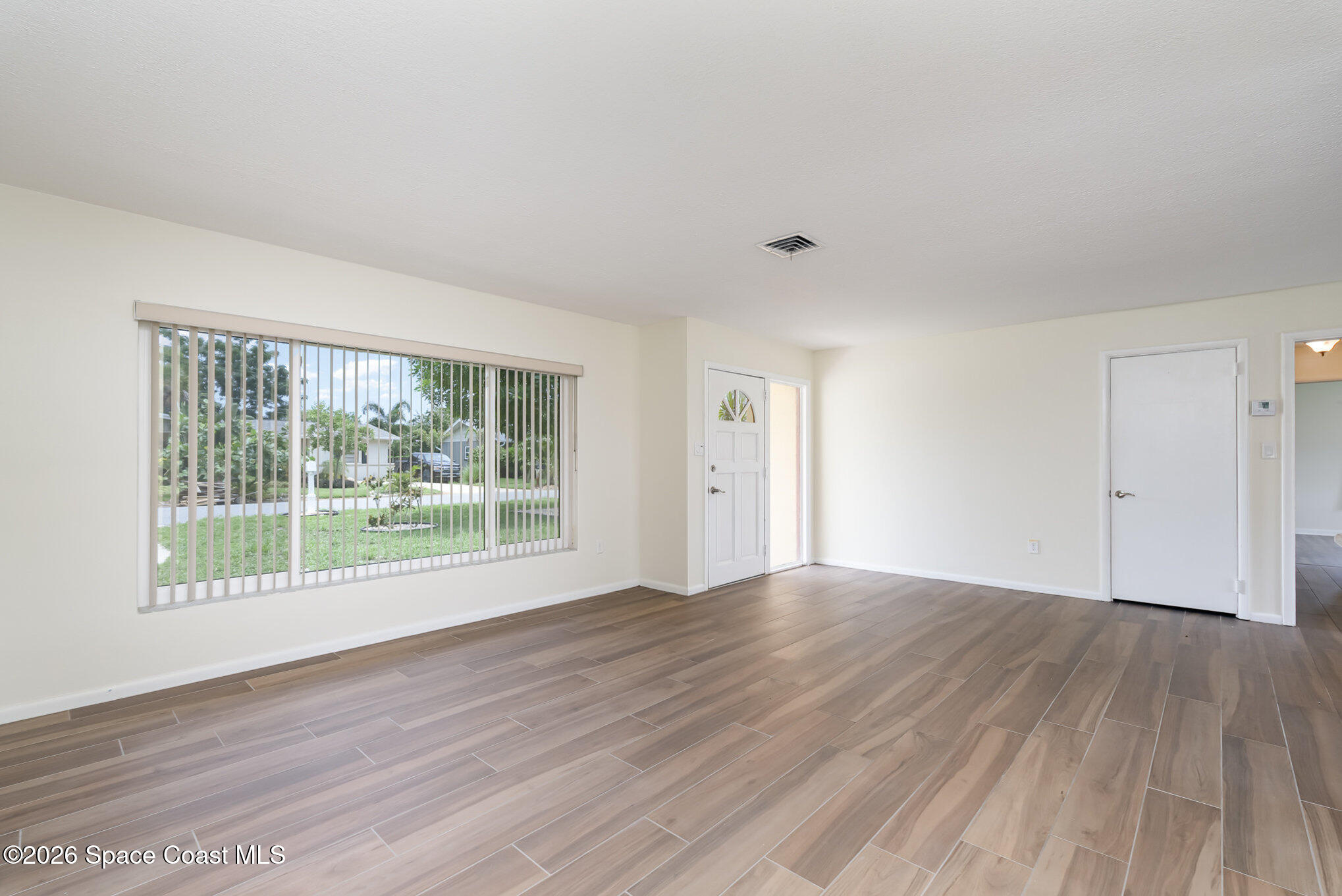 115 Gary Lane Cocoa, FL 32922 - Photo 3 of 29 a view of an empty room with wooden floor and a window