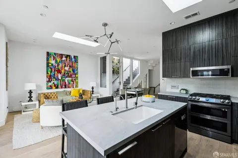 a kitchen with a sink a stove and chairs