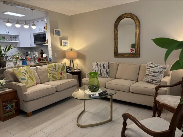 a living room with furniture a couch and a potted plant
