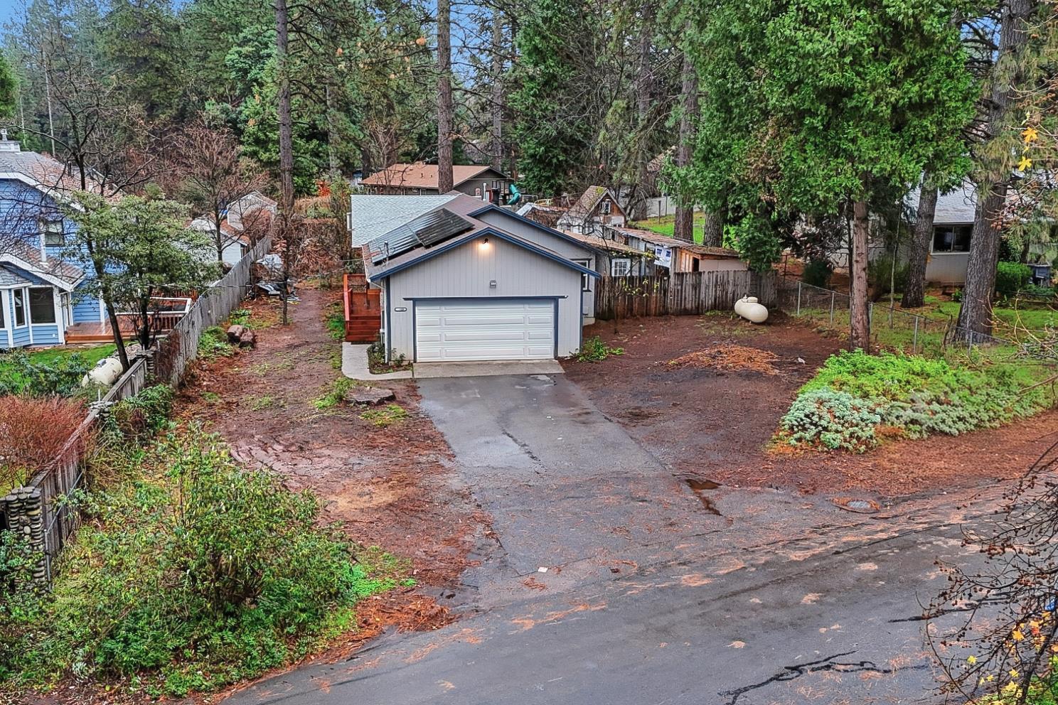a view of a house with a yard and large trees