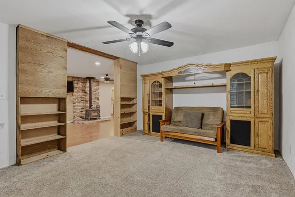 a living room with closet and ceiling fan