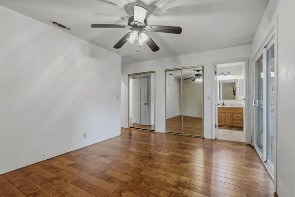 a view of an empty room with a window and a kitchen view