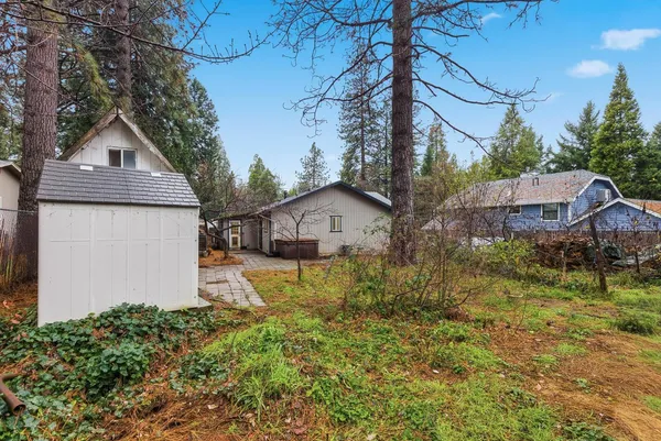 a front view of house with yard and trees in the background