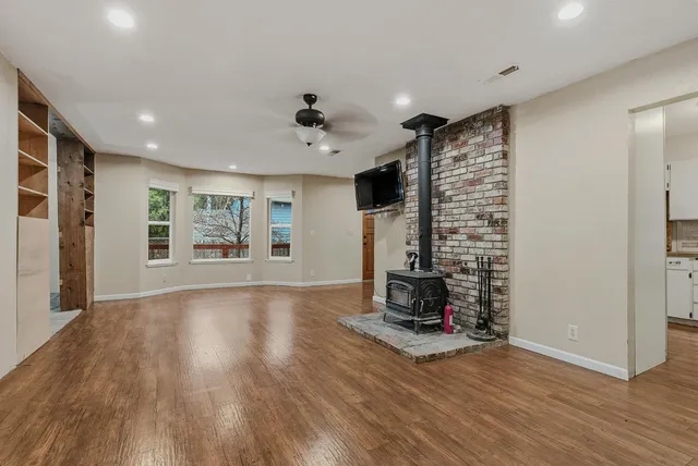 a view of an empty room with a fireplace and a window