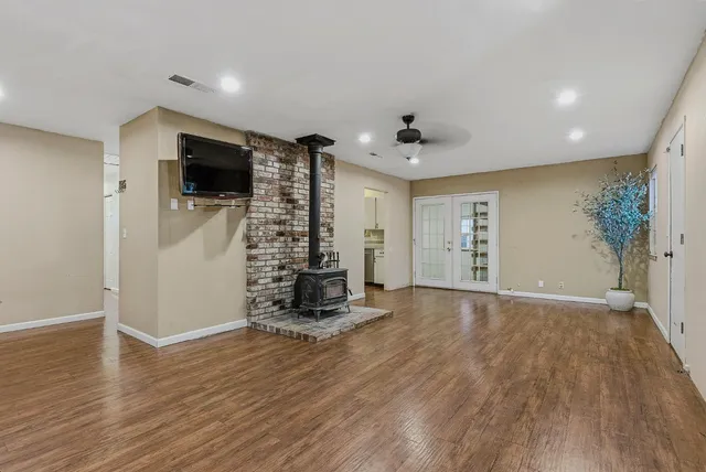a view of empty room with wooden floor and windows