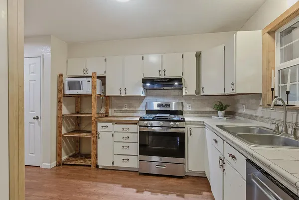 a kitchen with cabinets stainless steel appliances and a sink