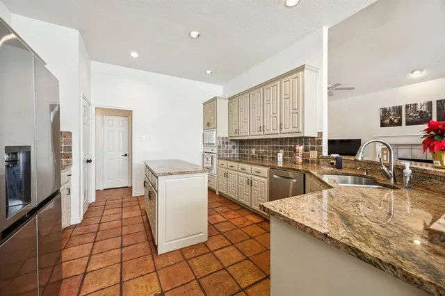 a kitchen with a sink a counter top space stainless steel appliances and cabinets