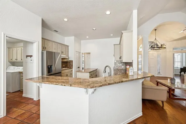 a kitchen with stainless steel appliances granite countertop a sink and a refrigerator