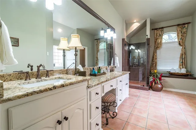 a spacious bathroom with a granite countertop sink mirror and bathtub
