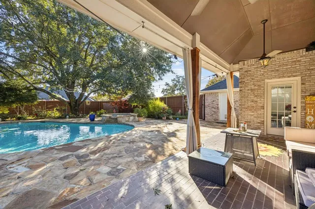 a view of a patio with couches and table and chairs and wooden fence