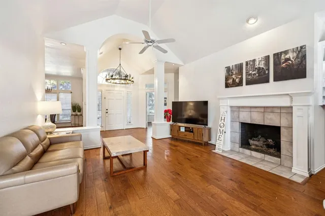 a living room with furniture a flat screen tv and a fireplace
