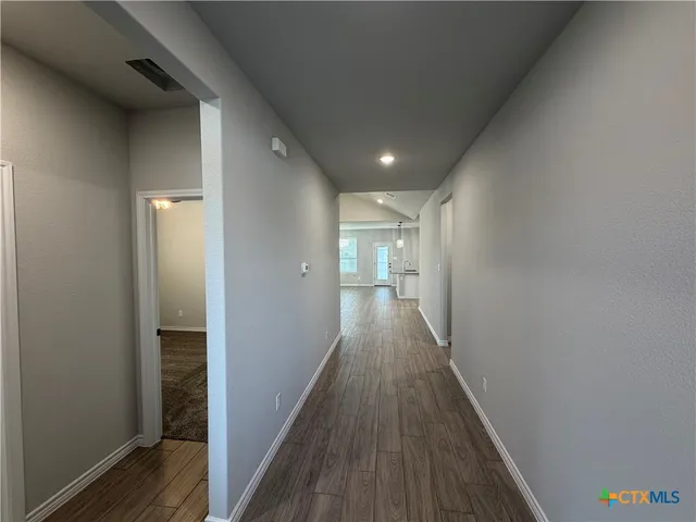 a view of hallway with wooden floor