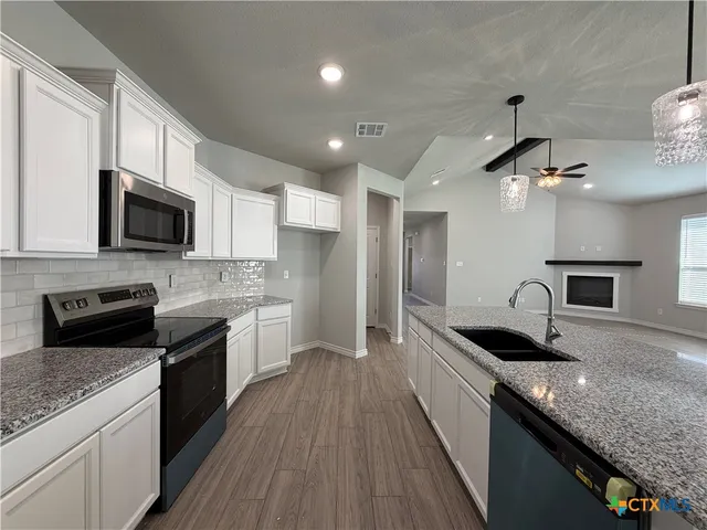a kitchen with granite countertop stainless steel appliances and sink