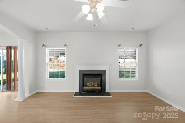 an empty room with windows and fireplace