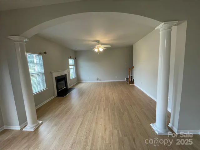 a view of empty room with wooden floor and fireplace