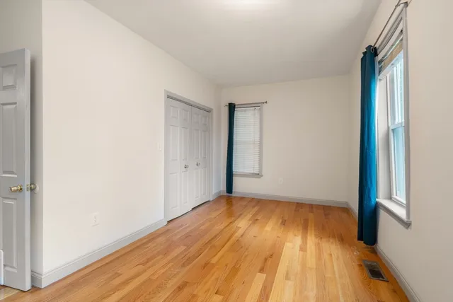 a view of a room with wooden floor and a window