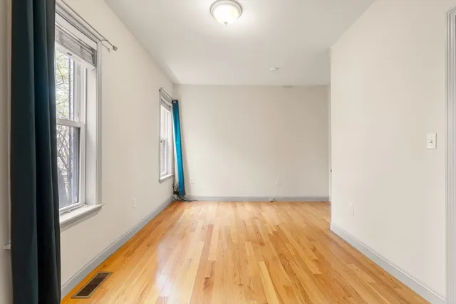 a view of a room with wooden floor and a window