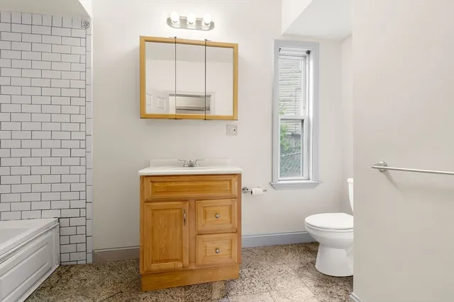 a bathroom with a toilet sink and mirror