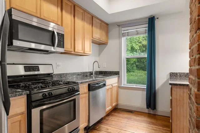 a kitchen with stainless steel appliances granite countertop a stove microwave and sink