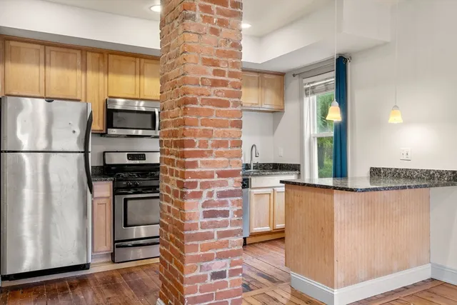 a kitchen with stainless steel appliances granite countertop a refrigerator and a stove