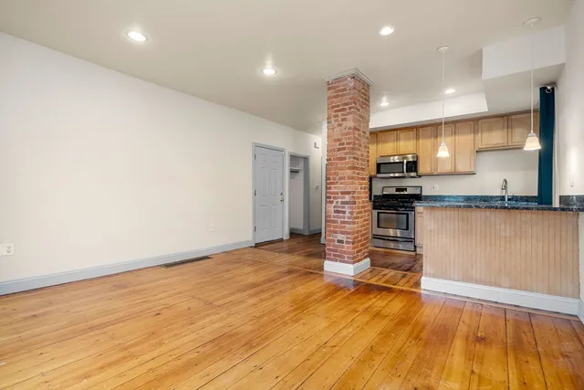 a view of kitchen with refrigerator and wooden floor