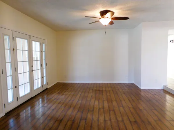 a view of room with hardwood floor and chandelier fan