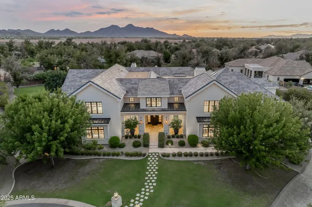 an aerial view of a house with a garden and lake view