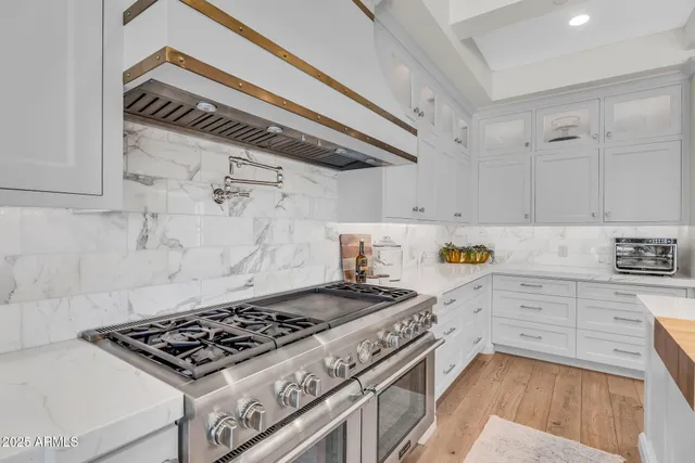a bedroom with a large bed chandelier and a window