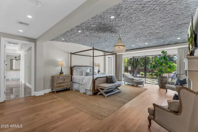 a bedroom with a large bed and a chandelier