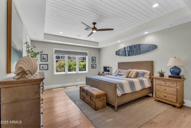 a dining room with wooden floor a chandelier a wooden table and chairs