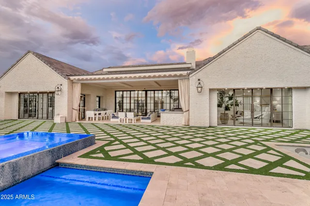 a living room with furniture a chandelier and a potted plant