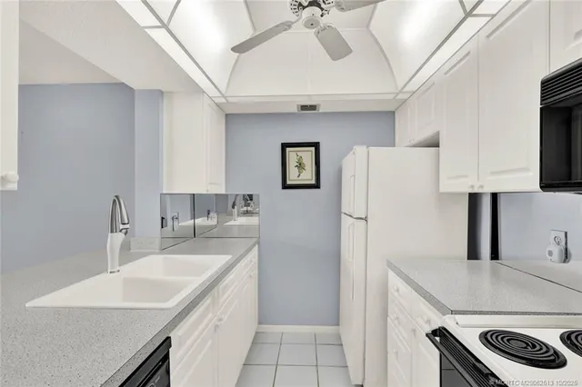 a kitchen with a sink a refrigerator and cabinets