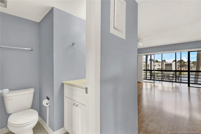 a bathroom with a toilet a sink and a large window