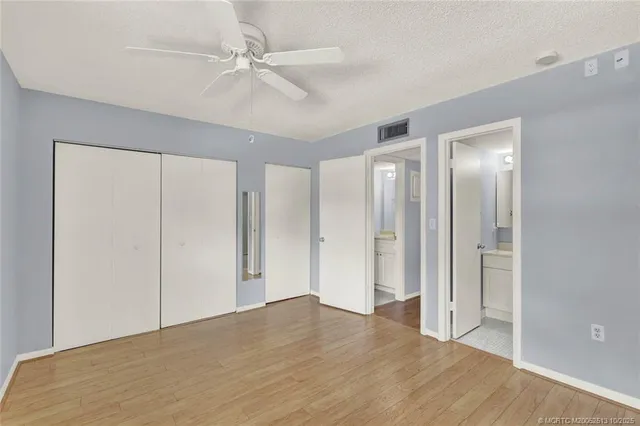 a view of an empty room with closet and a chandelier fan