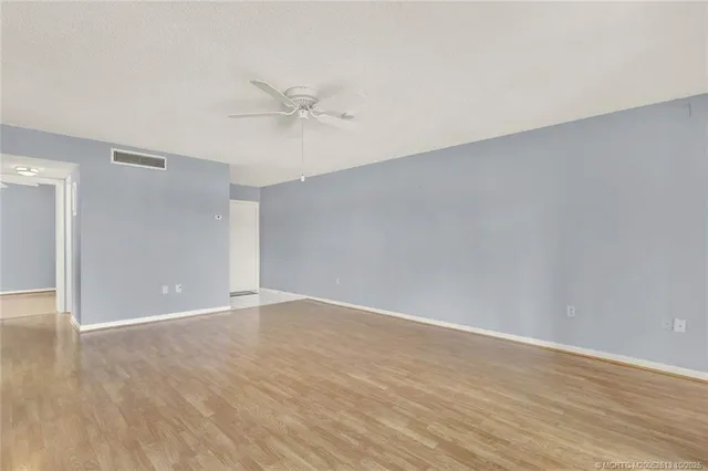 a view of an empty room with wooden floor