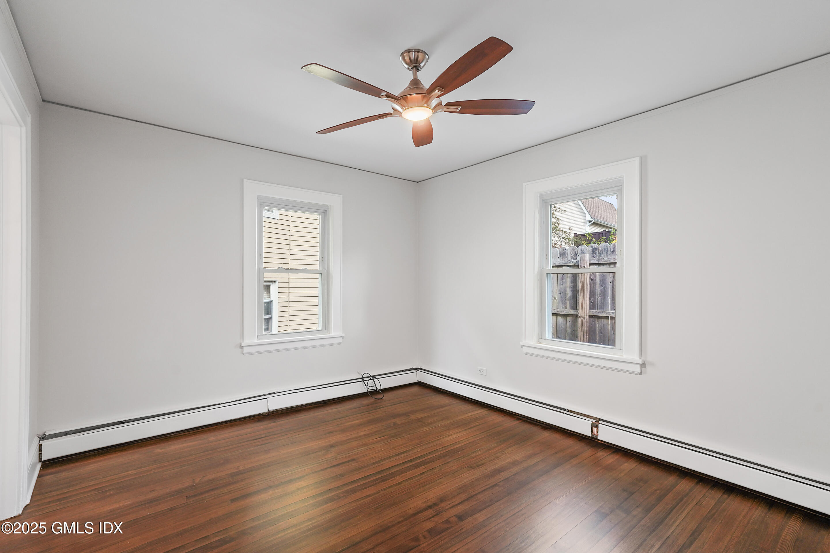 95 Byram Road Greenwich, CT 06830 - Photo 18 of 35 an empty room with wooden floor ceiling fan and windows