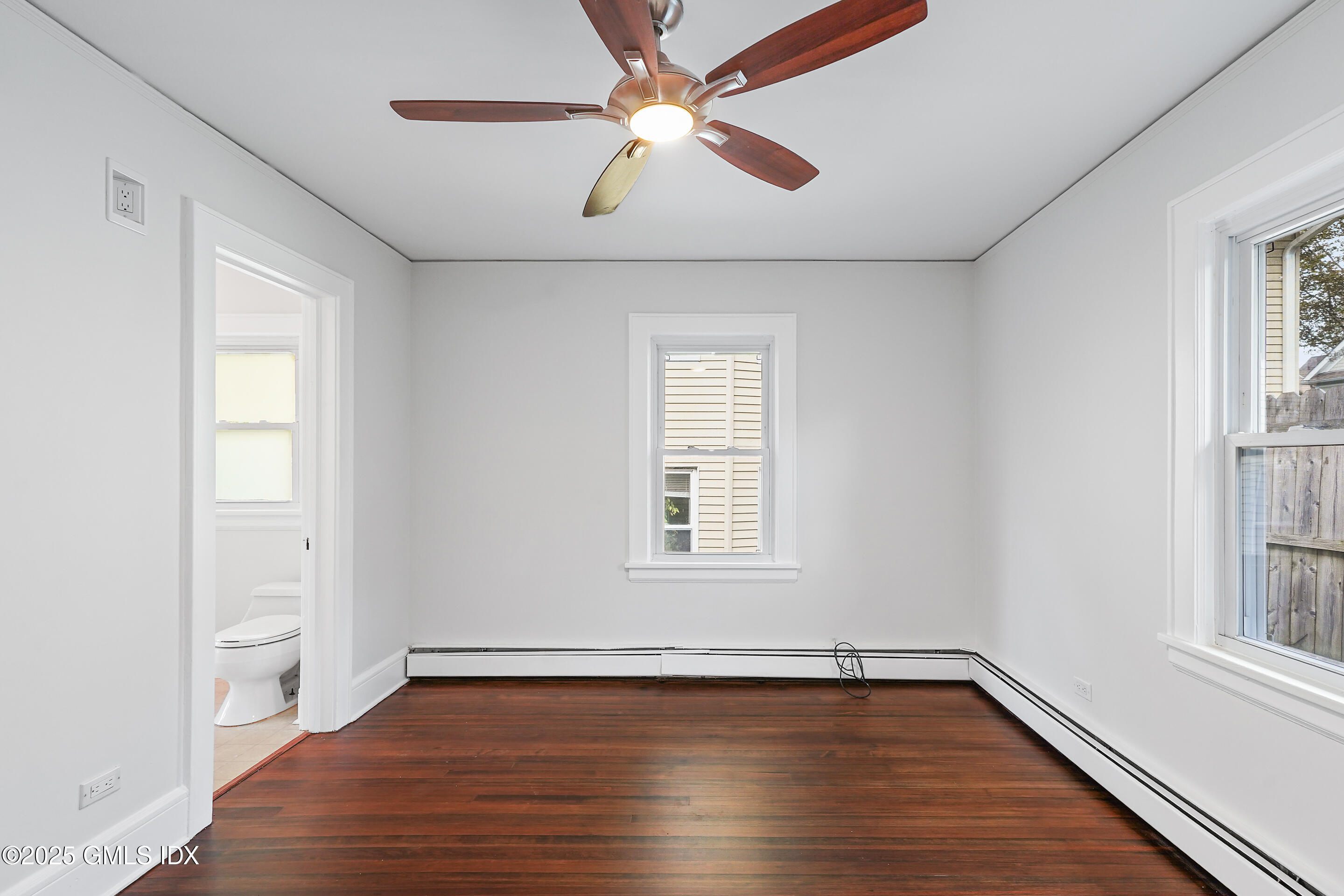 95 Byram Road Greenwich, CT 06830 - Photo 19 of 35 an empty room with wooden floor chandelier fan and windows