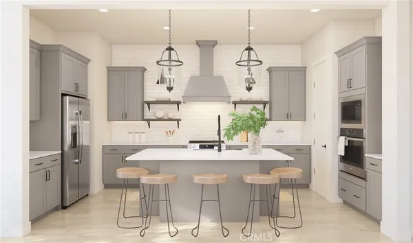 a kitchen with stainless steel appliances kitchen island granite countertop a dining table chairs and white cabinets